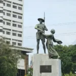 Monumen tokoh sejarah Indonesia di latar belakang arsitektur kota Jakarta sebagai simbol kepahlawanan